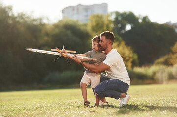 Joy, fun, weekend activities. Father and son are on the field together with toy plane