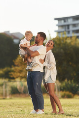 Fototapeta premium Parents and kid are happy. Mother and father are with son outdoors on the field