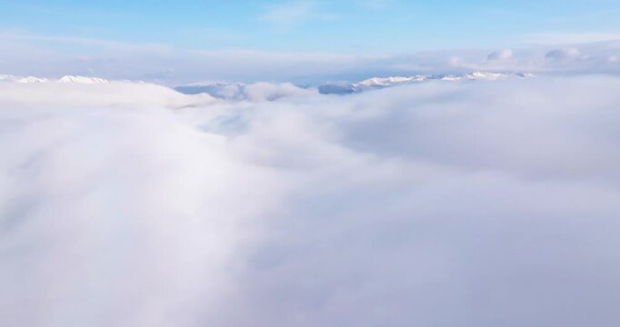 aerial view of snow mountain peak above the clouds of mist 