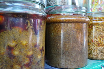 The jars of Indian mixed pickle which are traditional condiment made from various fruits or vegetables preserved in spices and oil