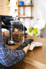 A woman pays contactlessly using a phone with NFC technology.