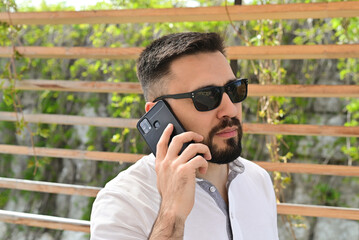 A man having a business conversation over the phone, focused and engaged in the discussion.