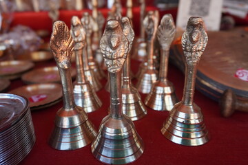 Several small, polished brass bells, likely Ghanti bells used in Hindu rituals which are commonly used during pooja ceremonies to create a sacred atmosphere and are believed to dispel negative energy
