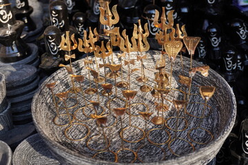 Golden Figurines in Textured Bowl, Artistic Symbolic Display with Abstract Elements