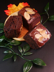 Dark chocolate brownies with crunchy almond topping slices, showing the details and depth of the...