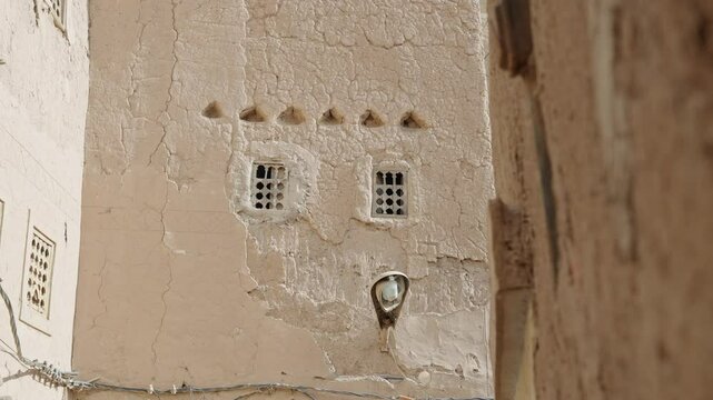 Close-up view of Moroccan architecture with white adobe and small windows with holes