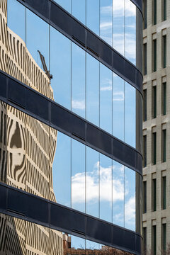 Fragmented reflections on the glass facade of a commercial building, showcasing urban symmetry and contemporary architecture.