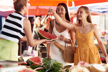 Buying fruits from the seller. Two women are together on the marker or bazaar