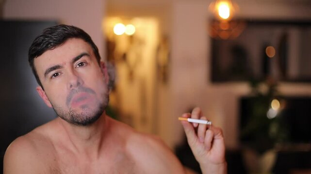 Attractive shirtless man smoking a cigarette 