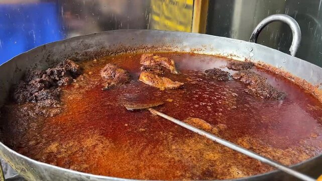 A big vessel containing oily Mutton and chicken chap in a road side stall in India.