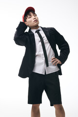 Young man in stylish outfit poses confidently with a playful twist in a contemporary setting
