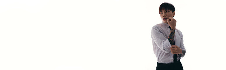 Young handsome asian man in a stylish suit striking a confident pose in a minimalistic setting