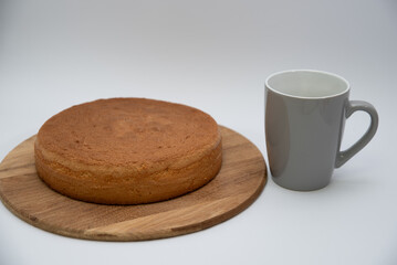 Homemade round sponge cake baked on a white background