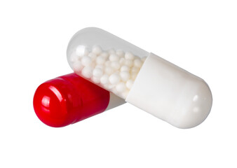 Colorful capsules with white granules displayed on a clean surface in a bright environment