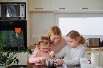 Easter baking chaos: mother and daughters in flour-covered pajamas, mixing ingredients