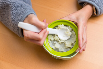 Woman mashing food for baby meal preparation