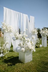 Elegant white floral arrangement on a bright sunny day for a wedding ceremony