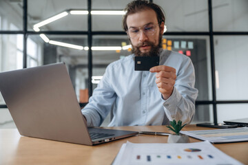 Obraz premium Holding credit card. Businessman is working in the office