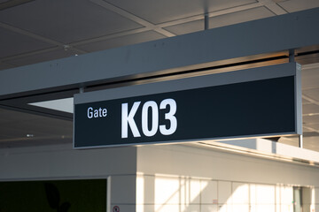 Obraz premium International airport ceiling mounted sign designating gate K03. Looking up shot, close up, no people
