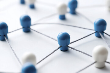 Network connections represented by blue and white pegs linked by strings, symbolizing collaboration and communication