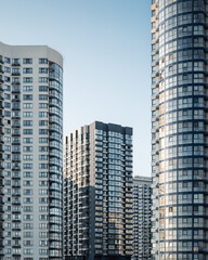 Modern district with residential high-rise buildings. Facades of stylish apartment buildings at sunset.