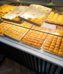 Traditional turkish sweets shop: baking sheets covered with baklava pastry dessert. 