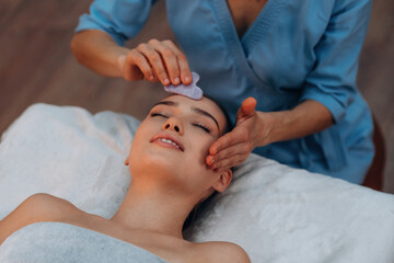 Facial massage. Relaxed young woman is with therapist in spa salon