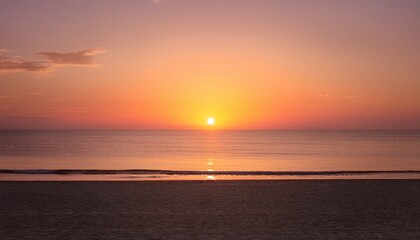 Fototapeta premium Tranquil minimalist beach sunset scene as the sun dips below the horizon, leaving behind a soft, beautiful gradient of orange and pink in the sky