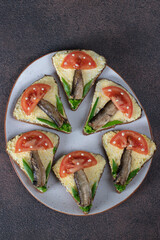 Sandwiches with sprats, tomatoes and green onions in the shape of mushrooms, Top view
