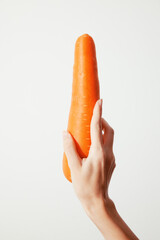 Person holding up carrot on white background, copy space for text or logo
