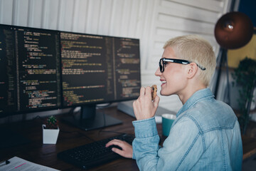Young professional woman coding at her home office in a casual denim outfit
