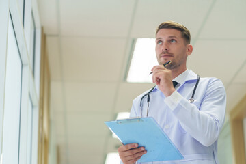 Portrait young caucasian doctor in uniform,holding clipboard and pen,thinking about evaluate patient data and treatment plan,with copy space for text