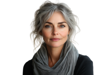 A confident woman with gray hair smiles softly, wearing a cozy gray scarf. Her calm expression invites connection and trust against a white backdrop.