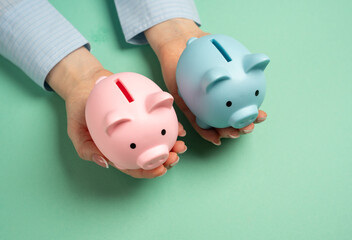 Two piggy banks of different sexes in outstretched hands. Combining household budgets. Merging finances, combining resources, and creating a shared budget in partnerships or family households