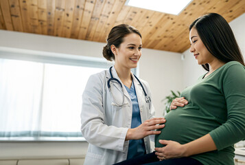 female doctor talking to her pregnant patient, giving her quality care and emotionally support.