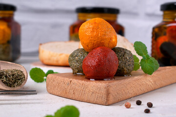 Labneh yogurt cheese balls in spices served on a small wooden board on a white background. Middle Eastern cuisine dish. Close-up