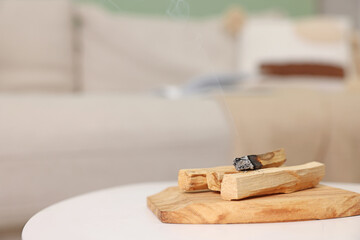 Palo santo sticks and burnt one on white table indoors, space for text