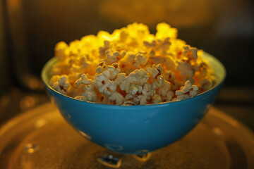 Bowl of tasty popcorn in microwave oven, closeup
