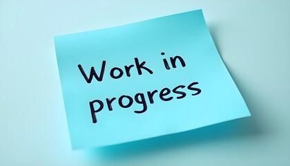 A bright blue sticky note with the phrase "Work in Progress" written in bold letters.