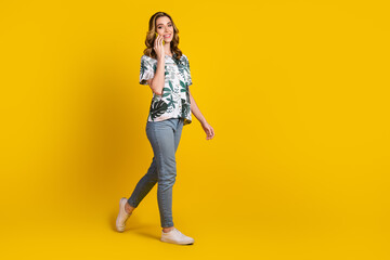 Young stylish woman in casual outfit posing confidently against a vibrant yellow background exuding joy and positivity.