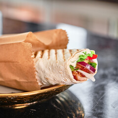 Wrapped Shawarma in a Paper Bag on a Plate