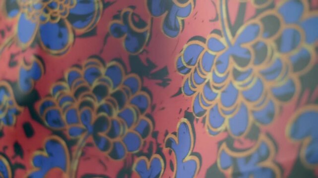 Red fabric with a beautiful floral pattern flutters in the wind. Closeup. Macro. Slow mo, slow motion, high speed camera, 200fps