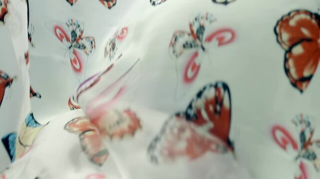 White fabric with beautiful butterflies falls, fluttering on a black background. Closeup. Macro. Slow mo, slow motion, high speed camera, 200fps