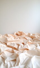 A soft, wrinkled fabric drapes over a surface against a plain wall.