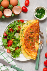 Cheese omelette with fresh green salad and toast on a plate