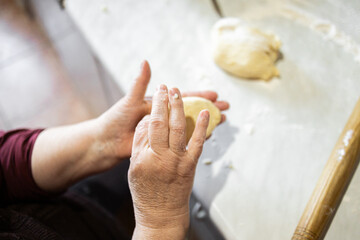 Grandma makes pies with meat, onion, egg. Homemade pies. Grandma's hands.