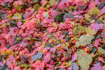 Aquarium fish fodder closeup.Food for aquarium fish in the form of colorful flakes.Top view
