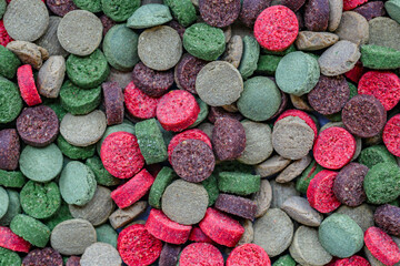 Aquarium fish fodder closeup.Bright multicolored pills for fish.Top view