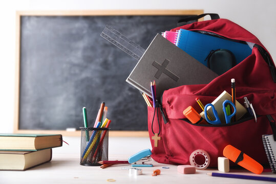Religious education with red backpack full of tools in classroom