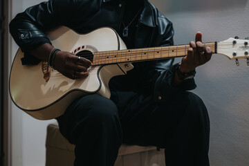 A photograph capturing a person strumming an acoustic guitar, emphasizing artistry and creativity.